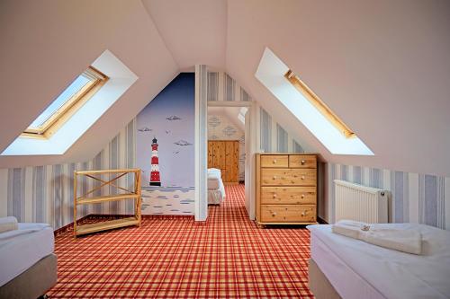 a attic room with a bedroom with a lighthouse on the wall at Hotel Godewind in Thiessow