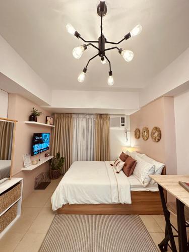 a bedroom with a bed and a chandelier at Cozy Nest Tagaytay in Tagaytay