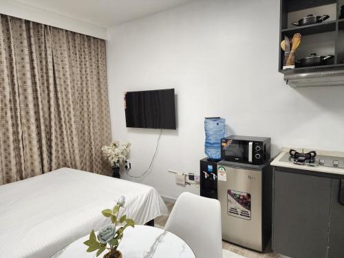 a room with a bed and a table and a tv at Mathel Studio Home in Marimbeti