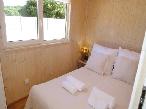 een slaapkamer met een bed met witte lakens en kussens bij Holiday homes with swimming pool, close to the sea in Wapnica