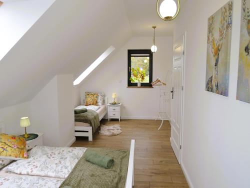 a white attic room with a bed and a couch at Green Hill Domyslow, 6 persons in Domysłów