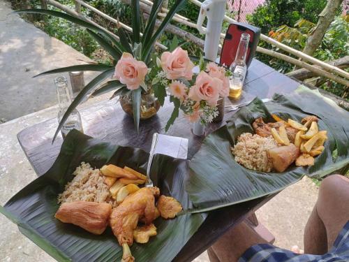 a table with two plates of food on a banana leaf at Eco Cabaña en el Campo in La Vega