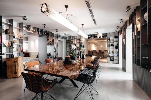 a kitchen with a table, chairs, and a refrigerator at Sir Savigny Hotel in Berlin