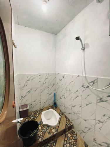 a bathroom with a toilet and a shower at Lavenda homestay syari'ah in Dieng