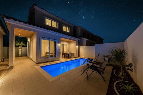 a house with a swimming pool at night at LEO癒Resort宮古島 Pool & Villa in Miyako-jima
