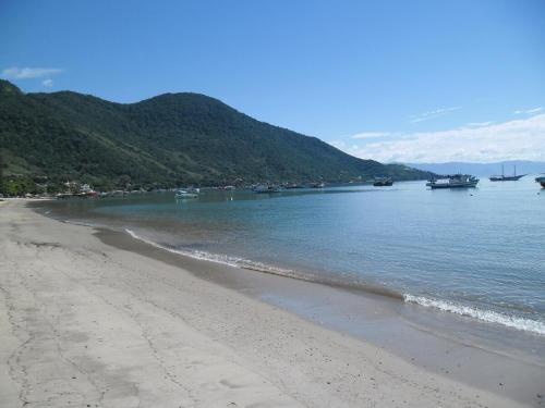 a beach with boats in a body of water at Casa Azul Jaraguá in São Sebastião