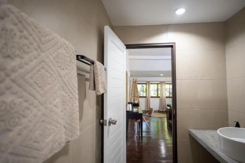 a bathroom with a sink and a white door at Baan Sawasdee Resort in Ko Lanta