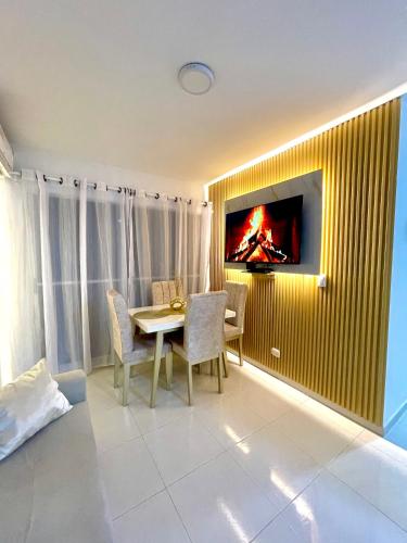 卡塔赫纳Vista Infinita de Cartagena Cerca del Centro Histórico的一间设有桌子的用餐室和墙上的电视