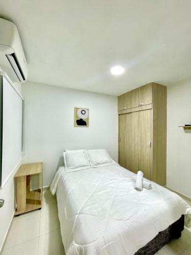 卡塔赫纳Vista Infinita de Cartagena Cerca del Centro Histórico的卧室里有一张白色的床和一个木柜