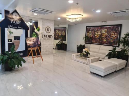a lobby with a couch and a painting on the wall at Ivory Residences in Davao City