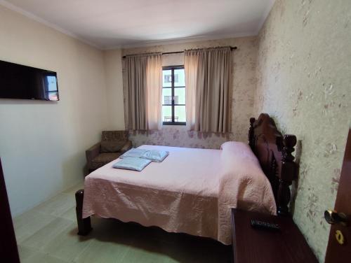 a bedroom with a bed and a window at Apartamento aconchegante no centro da cidade in Serra Negra