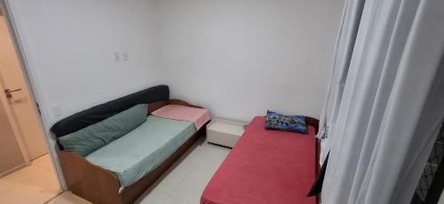 ein kleines Zimmer mit einem Sofa und einem Bett in der Unterkunft Apartamento 2 quartos na orla de Aracaju 2 in Aracaju