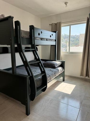 a bunk bed in a room with a window at Villa Yolanda in Acapulco