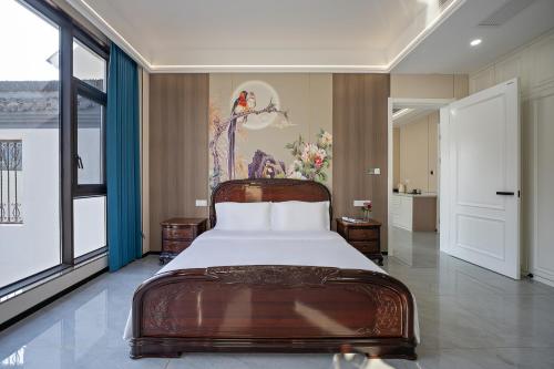 een slaapkamer met een bed en een schilderij aan de muur bij 花筑庐江满山红遍民宿 