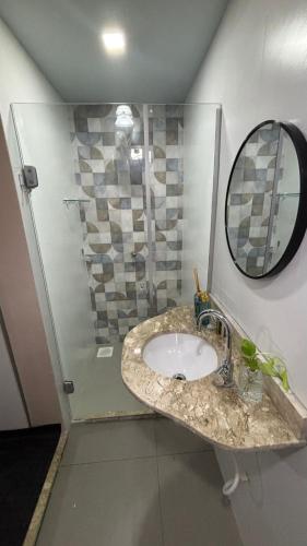 een badkamer met wastafel en douche met spiegel bij Casa Janela Azul in Belém