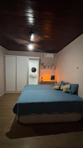 een slaapkamer met een groot bed met een blauwe deken bij Casa Janela Azul in Belém