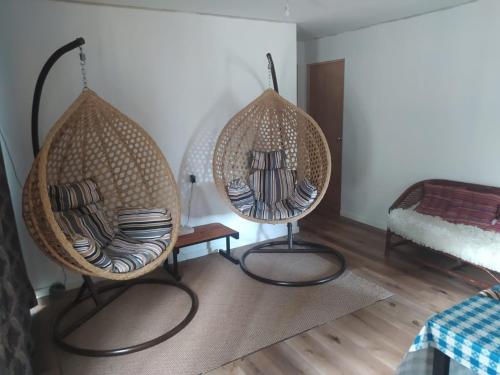 two wicker chairs sitting in a room with a bed at Cabaña entre eucaliptos en Huaquén 3D 1B más patio in Guaquen