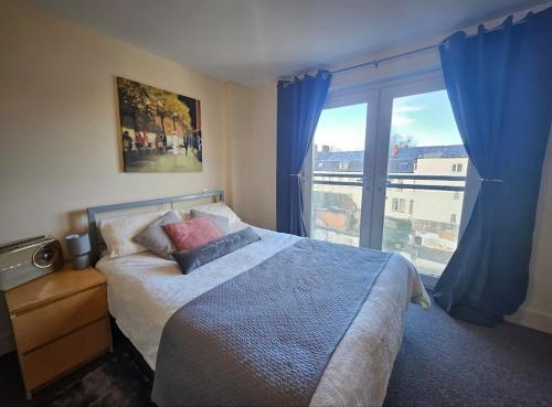 ein Schlafzimmer mit einem Bett und einem großen Fenster in der Unterkunft Cardiff City Apartment near Principality Stadium, Cardiff Arms Park & Cardiff Castle in Cardiff
