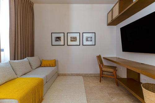 a living room with a couch and a flat screen tv at Casa KakMo in Izamal
