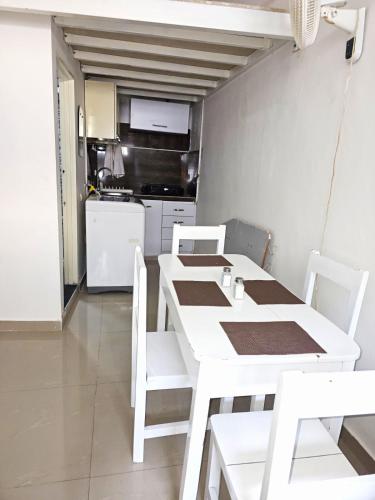 a white dining table and chairs in a kitchen at Apartaestudio - Miraflores in Cali