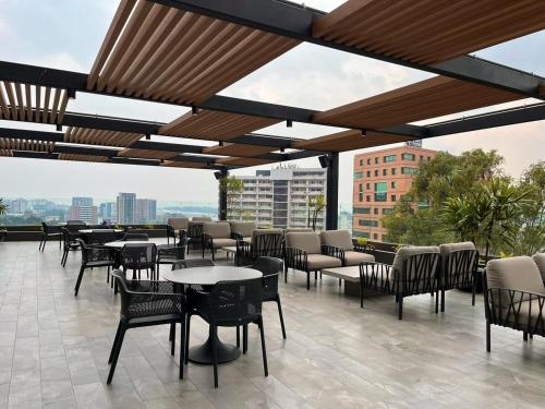 Un patio con mesas y sillas en un edificio. en Luxury stay in zone 14, en Estación Pamplona