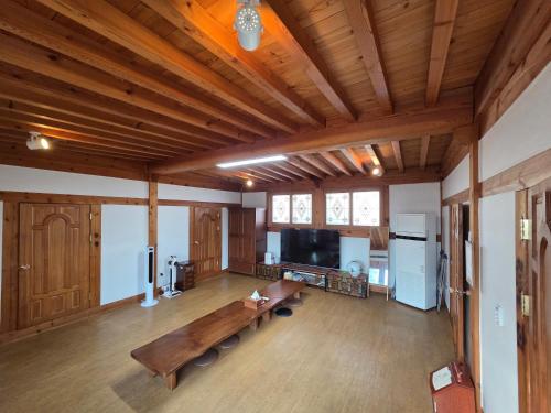 a large living room with a wooden ceiling at Yangyang 88 Hanok Stay in Yangyang