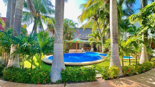 a resort with a swimming pool surrounded by palm trees at Hotel Barranquilla in Campeche
