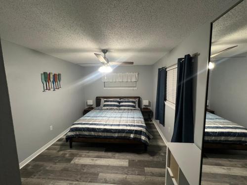 een slaapkamer met een bed en een plafondventilator bij Magical Mermaid Condo in New Smyrna Beach