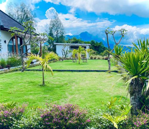 a garden with palm trees and a house at Hillside bali in Kubupenlokan