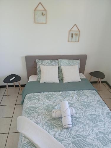 a bed with two towels on it with two tables at Lodge Larkansièl in Entre-Deux