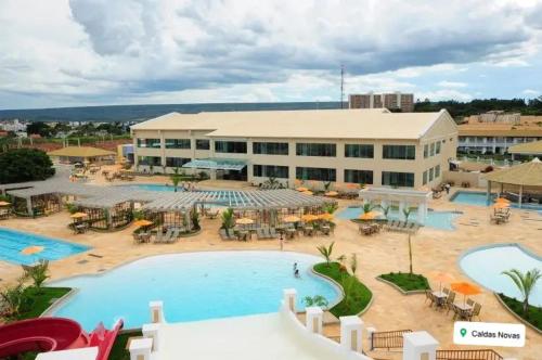 APT em CALDAS NOVAS في كالدس نوفاس: مبنى كبير أمامه مسبح كبير