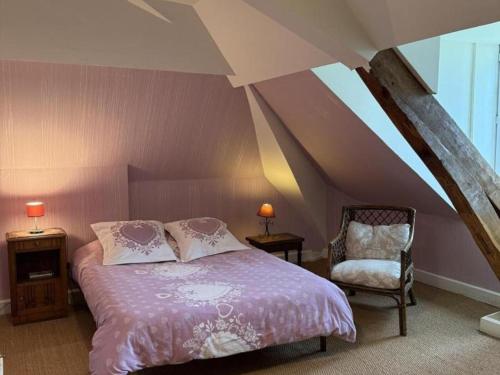 a bedroom with a bed and a chair in a attic at Maison de maître XIXe avec piscine partagée et jardin à Gipcy - FR-1-489-504 in Gipcy