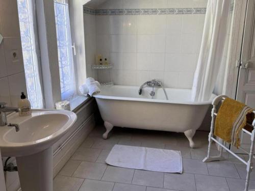 a white bathroom with a tub and a sink at Maison de maître XIXe avec piscine partagée et jardin à Gipcy - FR-1-489-504 in Gipcy