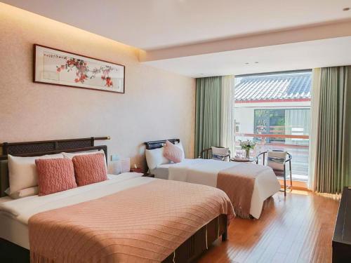 a hotel room with two beds and a window at Boying happywin Guofeng Shangyuan Lijiang Ancient Town South Gate Store in Lijiang