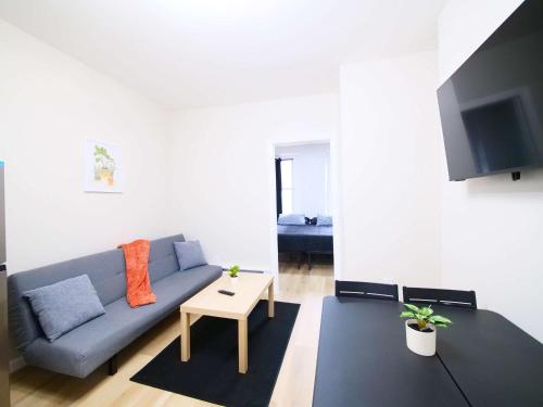 a living room with a blue couch and a table at Comfy 1-Bedroom Escape Close to NYC with Wifi in Paterson