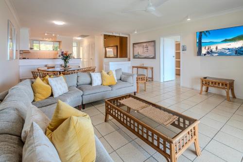 a living room with a couch and a table at Hibiscus Apartments on Hamilton Island by HIHA in Hamilton Island