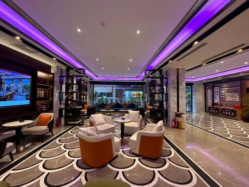a lobby with white chairs and tables and a television at Liban Hotel in Xi'an