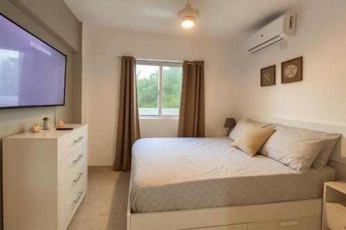 a bedroom with a bed and a large window at Premiun Apartment Riviera Colonial Santo Domingo in Calero