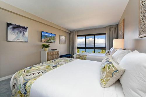 a bedroom with two beds and a large window at Kaanapali Alii 385 · ALII 385 Corner 2BD OceanFront Dream Vacati in Kaanapali