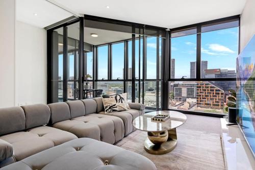 a living room with a couch and a table at Stylish 2BR Next to Parramatta Station with Pool in Sydney