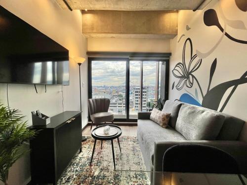 un salon avec un canapé et une grande fenêtre dans l'établissement Urban Corner in Zone 4, à Guatemala