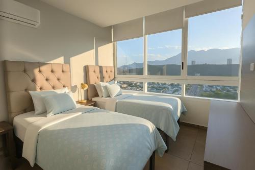 a hotel room with two beds and a large window at Stylish Panoramic Views City Loft in Monterrey