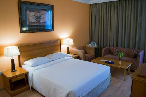 Habitación de hotel con cama y sofá en Le Royal Express Salmiya, en Kuwait