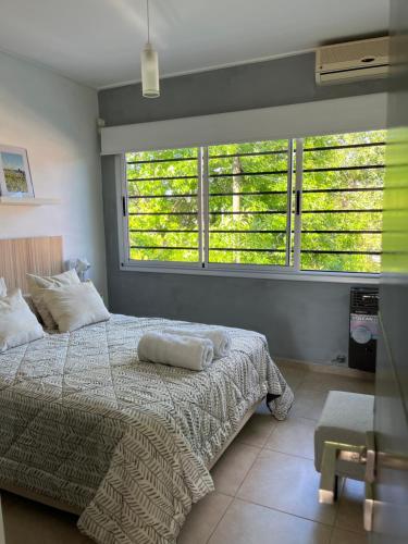 a bedroom with a bed and a large window at Orillas del Sol Triplex in Chascomús