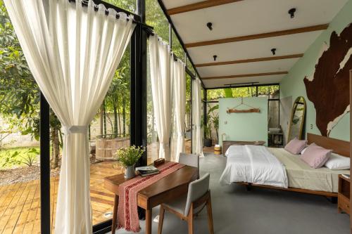 a bedroom with a bed and a desk and a table at Romantic Mirror-Clad Tiny with Private Hot Tub in Pedro Ruiz Gallo