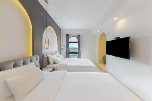 a bedroom with two beds and a flat screen tv at Sasang ND 1226 Hotel in Busan