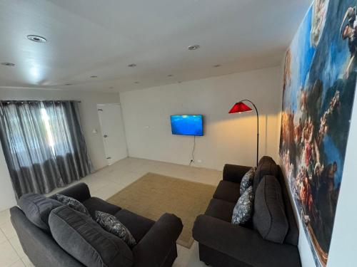 a living room with two couches and a flat screen tv at Bula Bliss Nadi - 2 Bedroom Apartment with Mountain View in Nadi