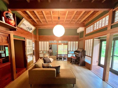 a living room with a couch and a piano at Anju KAGUYA 香宮宿 in Katori