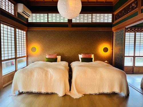 two beds in a room with windows at Anju KAGUYA 香宮宿 in Katori