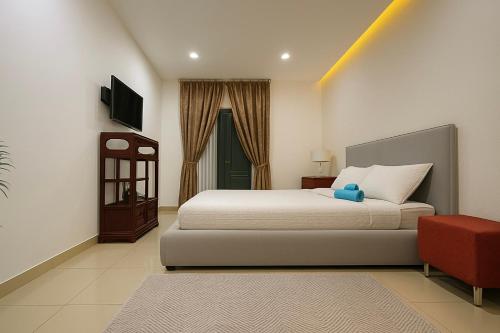 a bedroom with a large bed and a red chair at Modern Gzira 2BR Apartment Race2 in Il-Gżira